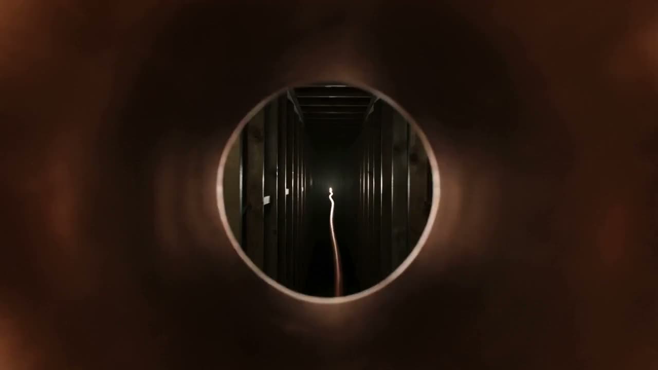 Inside a gleaming copper pipe, looking into the wall cavity